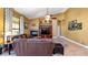 Living room features a stone fireplace, high ceilings, a ceiling fan, and large windows for natural light at 12127 Cypress Landing Ave, Clermont, FL 34711