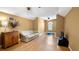 Cozy living room with tan walls, a wooden cabinet, light-colored wood floors, and a white sofa at 12127 Cypress Landing Ave, Clermont, FL 34711