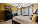 Serene primary bedroom featuring a fireplace, TV, tray ceiling, and natural light from the large windows at 12127 Cypress Landing Ave, Clermont, FL 34711