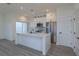 Bright open-concept kitchen with white cabinets, stainless steel appliances, and a center island at 1307 E Harding St, Orlando, FL 32806