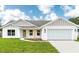 Charming single-story home with a well-manicured lawn, two-car garage, and a welcoming light-green front door at 13334 Sw 107 St, Dunnellon, FL 34432
