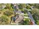 Aerial view shows a home with a pool, mature trees, and green landscaping at 13753 Via Roma Cir, Clermont, FL 34711