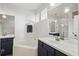Bathroom featuring double sinks, a soaking tub, decorative windows, and updated fixtures at 13753 Via Roma Cir, Clermont, FL 34711