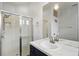 Bathroom with glass enclosed shower, single vanity with dark blue cabinet, mirror and modern fixtures at 13753 Via Roma Cir, Clermont, FL 34711