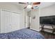 Bedroom with ceiling fan, double closets, tv on a stand, and doorway to the bathroom at 13753 Via Roma Cir, Clermont, FL 34711