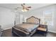 Bedroom with a padded headboard, side tables, a leather bench, and dark wood flooring throughout at 13753 Via Roma Cir, Clermont, FL 34711