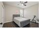 Cozy bedroom featuring a tufted headboard, ceiling fan, and wood-look flooring at 13753 Via Roma Cir, Clermont, FL 34711