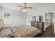 Comfortable bedroom featuring a ceiling fan, large dresser and dark wood flooring throughout at 13753 Via Roma Cir, Clermont, FL 34711