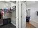 Walk-in closet and view of a bathroom with a soaking tub and vanity with blue cabinets at 13753 Via Roma Cir, Clermont, FL 34711