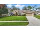 Charming single-story home with a well-manicured lawn and two-car garage at 13753 Via Roma Cir, Clermont, FL 34711