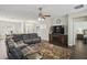 Inviting living room featuring an area rug, dark wood floors, and a comfortable sectional sofa at 13753 Via Roma Cir, Clermont, FL 34711