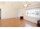 Open living room featuring wood-look floors, a ceiling fan, and a front door at 13828 Se 85Th Cir, Summerfield, FL 34491