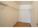 Empty walk-in closet with custom shelving and wood floor at 13828 Se 85Th Cir, Summerfield, FL 34491