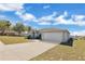 Exterior shot showcasing the home's driveway, two-car garage and the well-manicured lawn at 1391 Willow Crest Dr, Clermont, FL 34711