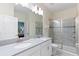 Bright bathroom with dual vanity, walk-in shower with glass enclosure and views to the bedroom at 1524 Flange Dr, Davenport, FL 33896