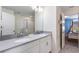 Bathroom vanity with double sinks and gray counters, leading to a bedroom with a bunk bed at 1524 Flange Dr, Davenport, FL 33896