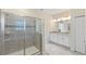 Bathroom boasts a glass-enclosed shower and double vanity with modern lighting and neutral color palette at 1524 Flange Dr, Davenport, FL 33896