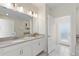 Bright bathroom featuring double sink vanity, modern fixtures, and a door leading to outdoor space at 1524 Flange Dr, Davenport, FL 33896