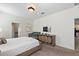 Well-lit bedroom featuring a queen bed, crib, dresser with a TV, and adjacent bathroom at 1524 Flange Dr, Davenport, FL 33896