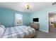 Bedroom suite featuring a bed, a TV on the wall and a dresser, decorated in light blue at 1524 Flange Dr, Davenport, FL 33896