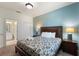 Well-decorated bedroom with a queen bed, adjacent bathroom, a closet and soft blue accent wall at 1524 Flange Dr, Davenport, FL 33896