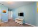 The bedroom features blue walls, white trim, a TV on the wall and an open doorway into another room at 1524 Flange Dr, Davenport, FL 33896