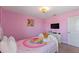 Charming pink bedroom with a playful theme, complete with a cozy bed and ample natural light at 1524 Flange Dr, Davenport, FL 33896