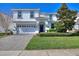 Charming two-story home with manicured lawn, paver driveway, and attached two-car garage in a well-maintained neighborhood at 1524 Flange Dr, Davenport, FL 33896