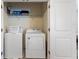 Convenient laundry room equipped with washer, dryer, and storage shelf at 1524 Flange Dr, Davenport, FL 33896