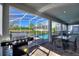 Screened-in patio featuring an outdoor kitchen area, dining table, and a refreshing view of the pool at 1524 Flange Dr, Davenport, FL 33896