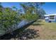Lush backyard with white fence, mature trees, and a well-kept lawn, offering a serene outdoor space at 16 General Doolittle Rd, Daytona Beach, FL 32124