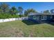 View of the blue exterior of the home from the grassy backyard at 16 General Doolittle Rd, Daytona Beach, FL 32124