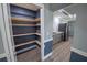 Walk-in pantry with wooden shelving, adjacent to the kitchen with stainless steel appliances at 16 General Doolittle Rd, Daytona Beach, FL 32124