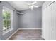 Neutral bedroom featuring a high ceiling, double closet, ceiling fan, light gray walls and wood-look floors at 16017 Harbar Oaks Dr, Montverde, FL 34756