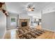 Bright living room featuring a brick fireplace, hardwood floors, and open access to the kitchen at 16017 Harbar Oaks Dr, Montverde, FL 34756