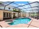 Screened in in-ground pool and spa with brick deck and lush landscaping at 16017 Harbar Oaks Dr, Montverde, FL 34756