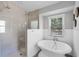 Bathroom with a walk-in shower with dual shower heads, a freestanding tub, and a window for natural light at 16017 Harbar Oaks Dr, Montverde, FL 34756