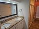 Bathroom vanity featuring double sinks, granite countertops, and a framed mirror at 16017 Harbor Oaks Dr, Montverde, FL 34756