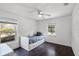 Well-lit bedroom featuring dark hardwood floors, a ceiling fan, and a bed with built-in storage drawers at 16017 Harbar Oaks Dr, Montverde, FL 34756
