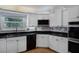 Bright kitchen with white cabinets, black countertops, and tiled backsplash at 16017 Harbar Oaks Dr, Montverde, FL 34756