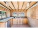This outdoor kitchen features knotty pine walls, sink, mini refrigerator, and ample counter space at 16017 Harbar Oaks Dr, Montverde, FL 34756