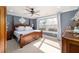 Cozy bedroom featuring a wooden four-poster bed, ceiling fan, and bright natural light at 16800 Se 80Th Bathurst Ct, The Villages, FL 32162