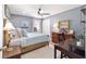 Cozy bedroom features a ceiling fan, soft blue walls, and a neutral carpet at 16800 Se 80Th Bathurst Ct, The Villages, FL 32162
