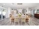 Bright dining room showcasing a farmhouse-style table and chairs, decorative lighting, and an adjacent modern kitchen at 16800 Se 80Th Bathurst Ct, The Villages, FL 32162