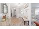 Bright and airy entryway featuring wood-look flooring, a decorative mirror, and a cozy bench seating area at 16800 Se 80Th Bathurst Ct, The Villages, FL 32162