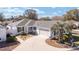 Charming home with a well-manicured lawn, a circular driveway, and a neutral color scheme at 16800 Se 80Th Bathurst Ct, The Villages, FL 32162
