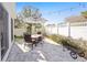 Cozy patio with a brick-style floor, dining table with an umbrella, and a white fence at 16800 Se 80Th Bathurst Ct, The Villages, FL 32162
