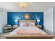 Bedroom with blue accent wall, lamps, and a chandelier at 17291 Saw Palmetto Ave, Clermont, FL 34714