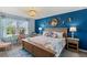 Bedroom with a blue accent wall, bed, and desk near window at 17291 Saw Palmetto Ave, Clermont, FL 34714