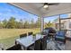 Relaxing screened patio with dining area overlooking the fenced backyard and lush greenery at 17291 Saw Palmetto Ave, Clermont, FL 34714